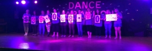 Dance marathon participants holding signs showing $39,088.90 raised